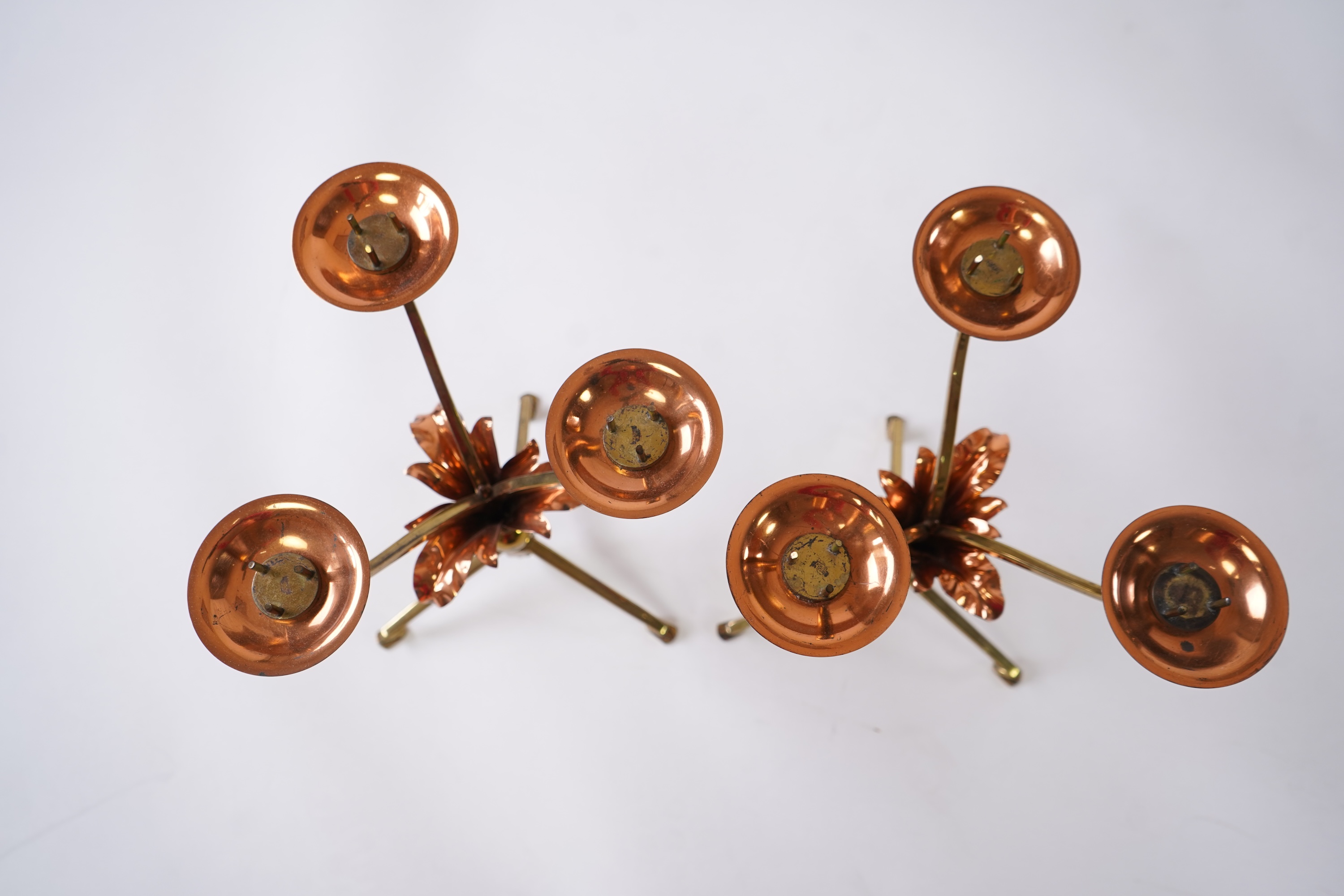 W.A.S. Benson & Co.: A pair of Arts and Crafts gilt brass and copper three branch candelabra
